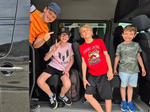 Kids climbing into the Pacific Top Team van for after-school pickup
